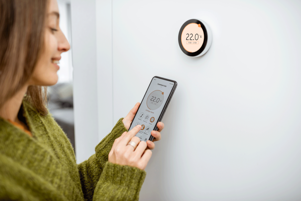 .woman setting thermostat with phone